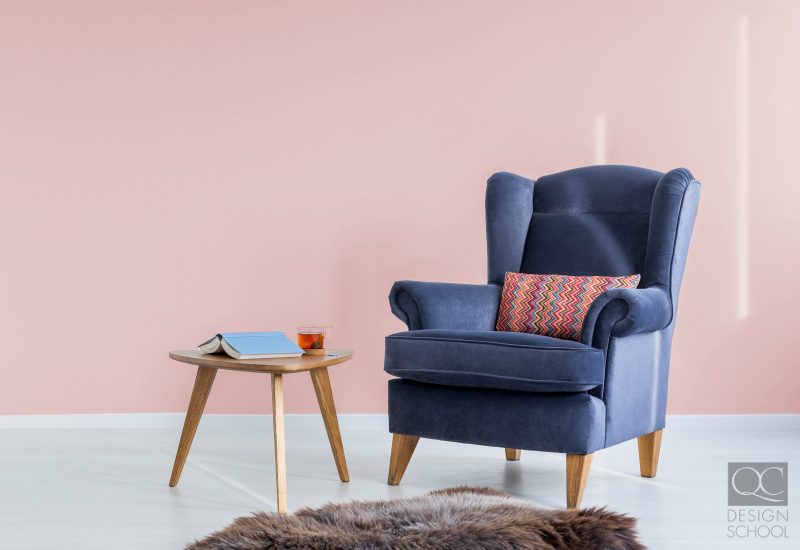 Pastel pink colored wall and blue chair.