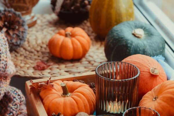 Best Halloween decorations with cozy pumpkins, pinecones, candles, and seasonal gourds arranged on a windowsill for festive Halloween home decor.
