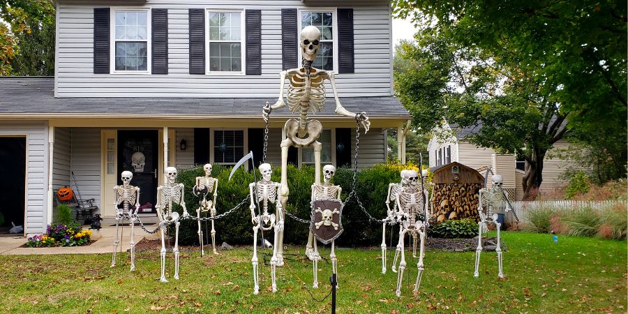 Best outdoor Halloween decorations featuring a front yard display of life-size skeletons creating a spooky and fun haunted house vibe.