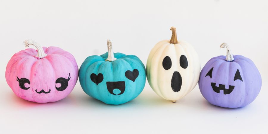 Homemade Halloween decorations indoors with colorful painted pumpkins featuring cute and spooky faces for a fun DIY Halloween craft idea.