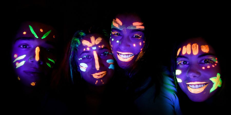 Cool Halloween decorations and party ideas with neon face paint glowing under blacklight, creating a spooky and fun atmosphere.