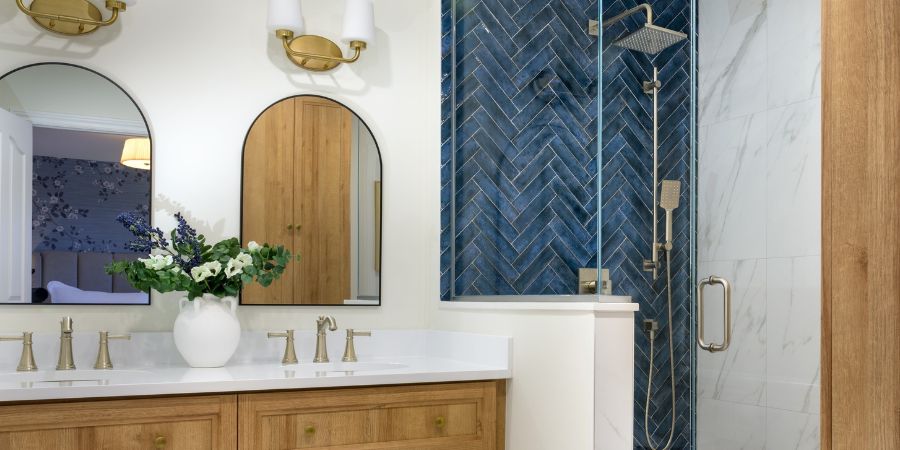 Modern bathroom design with blue herringbone tile shower and double vanity, shown as part of an interior design portfolio template for professional presentation.