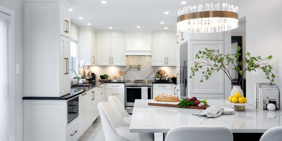 Bright modern kitchen design with white cabinetry, gold hardware, and statement chandelier, included in an interior design student portfolio example to highlight project skills.