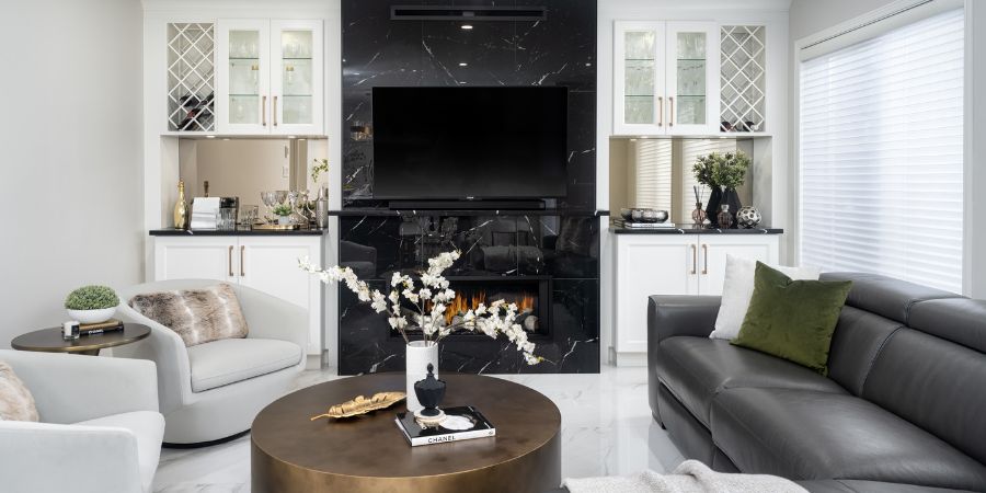 Contemporary living room design with black marble fireplace and gold accents, featured in an interior design portfolio website to showcase modern luxury styling.