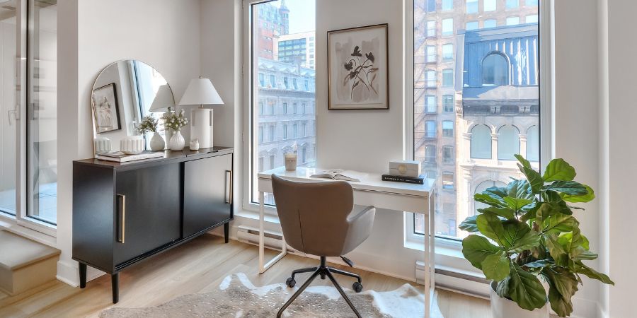 Bright home office with large windows and modern furniture, a perfect example of what an interior design portfolio looks like when showcasing clean, professional spaces.
