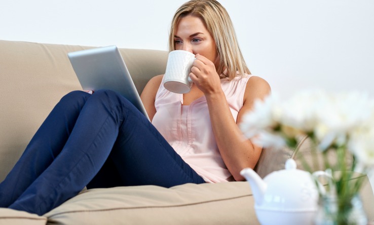 Lady sipping coffee using tablet
