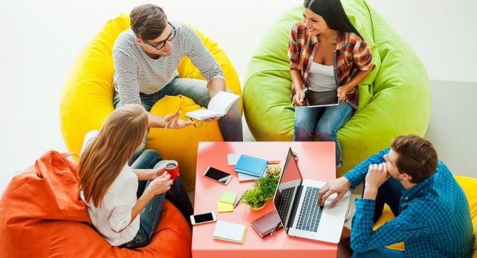Four people hold a business meeting on beanbag chairs