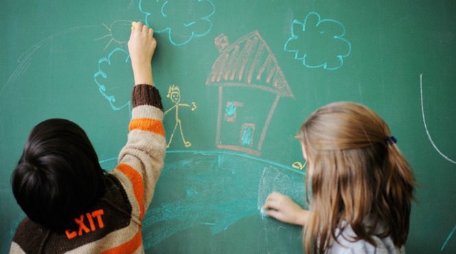Kids drawing on a chalkboard