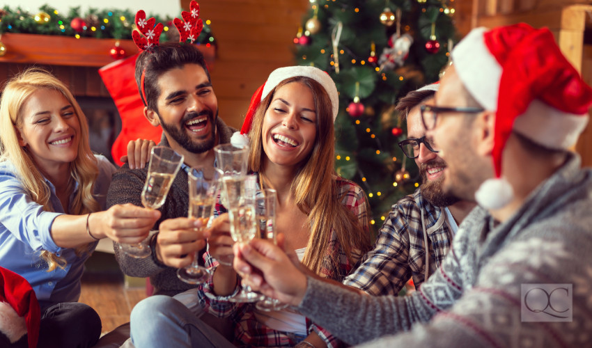 friends at a house party exchanging gifts laughing and drinking champagne - christmas decorations in home decor