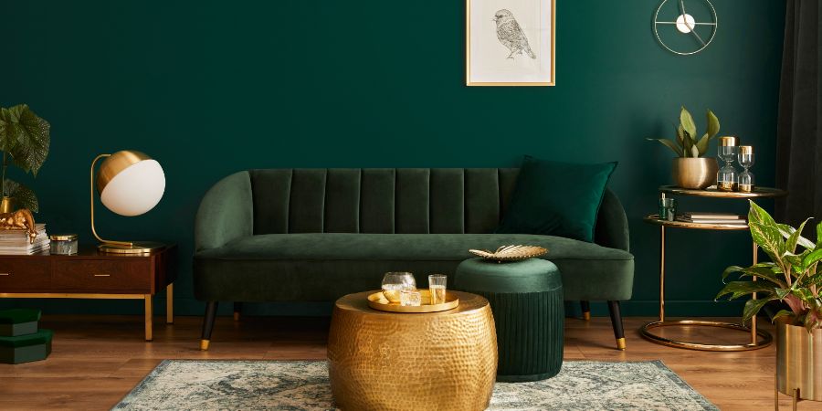 Luxury living room in house with modern interior design, green velvet sofa, coffee table, pouf, gold decoration, plant, lamp, carpet, mock up poster frame and elegant accessories. Template. New Year's resolutions article.