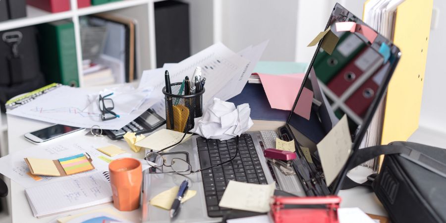 Messy and cluttered office desk, Organizing mistakes article.